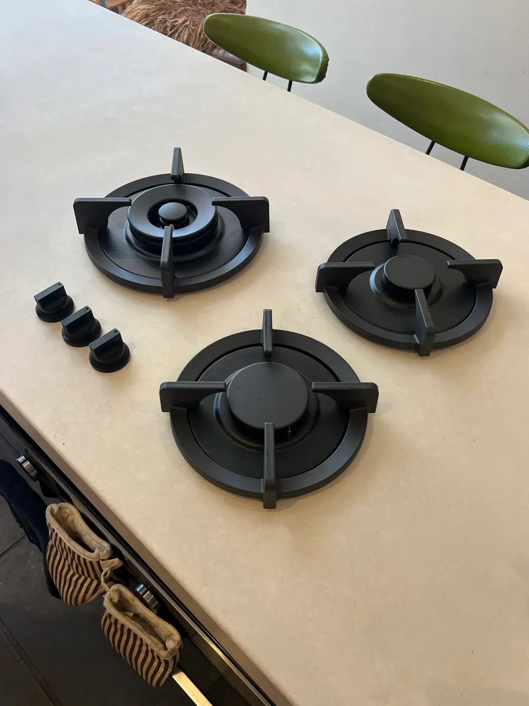 Black gas cooktop installed in a stone benchtop